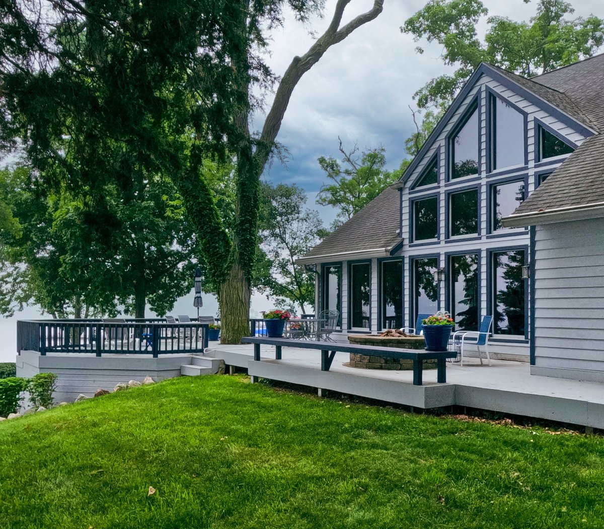 Upscale home on a Lake Washington hillside with a deck, mature evergreen trees and a grassy yard