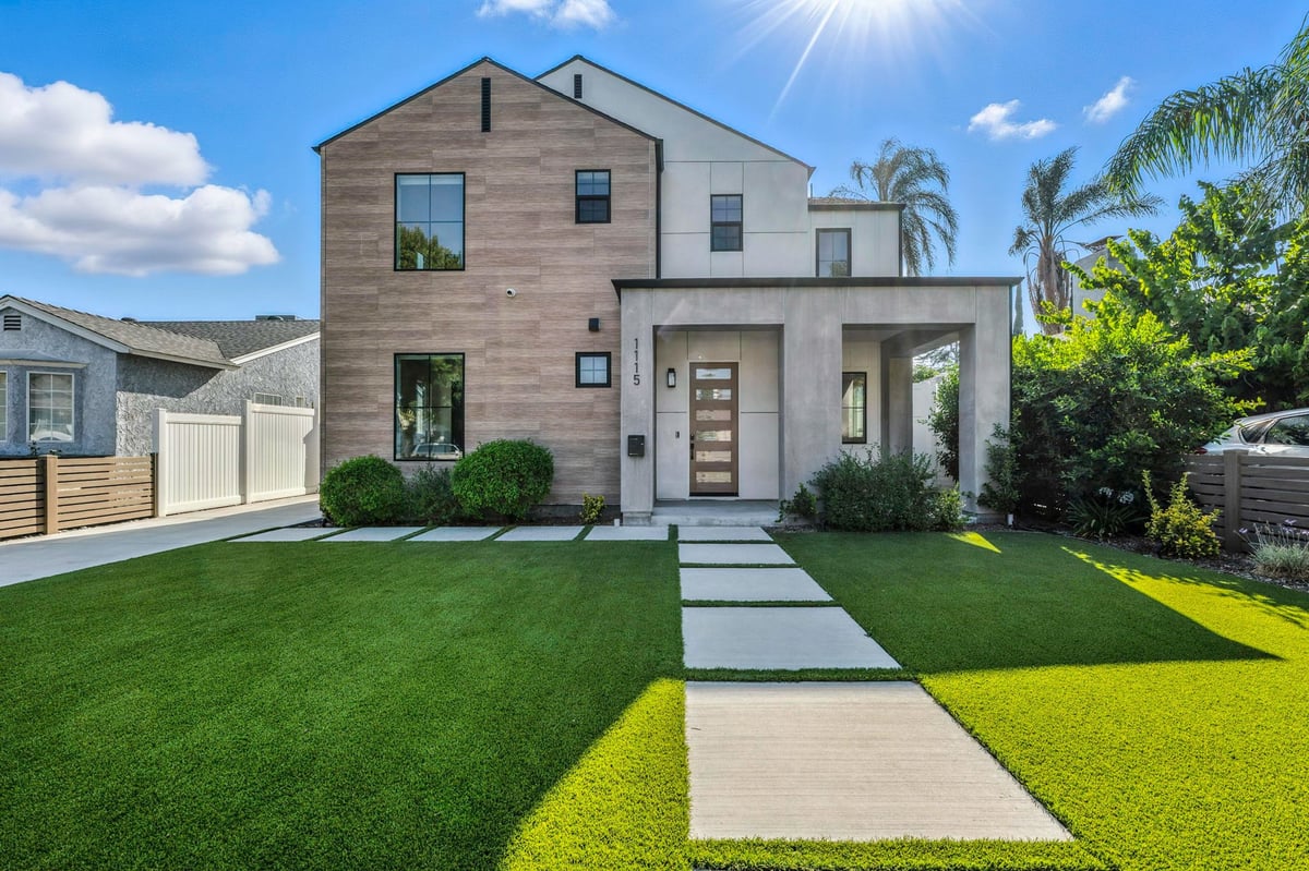 Manicured lawn in front of a modern suburban Eastside home with lush greenery